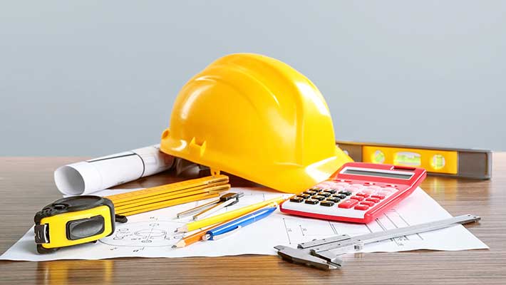 Construction blueprints with tools and helmet